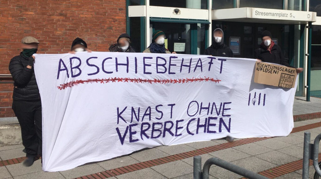 Menschen halten ein Banner "Abschiebehaft - Knast ohne Verbrechen"